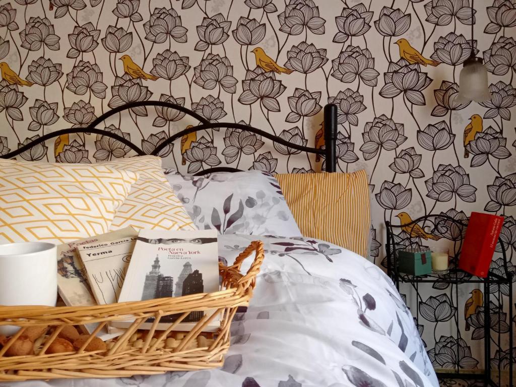 a bedroom with a bed with a basket of books at Casa La nana de Lorca a 15 min de Granada in Fuente Vaqueros