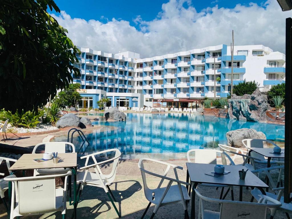 un resort con piscina, tavoli e sedie di Estudio El Colibrì a San Miguel de Abona