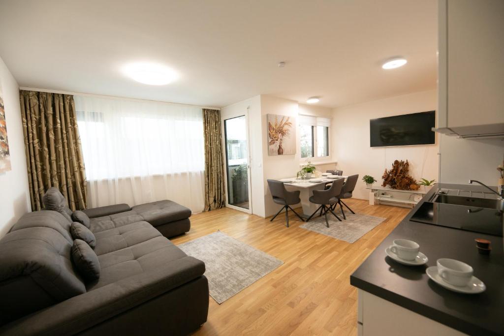 a living room with a couch and a table and a kitchen at Schönes Living am Donauufer in Vienna