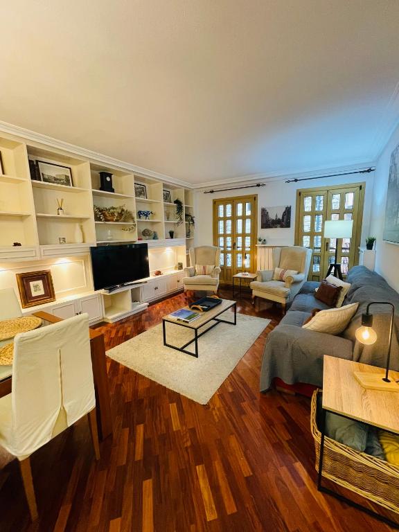 a living room with a couch and a tv at Atico al lado del Ayuntamiento in Oviedo