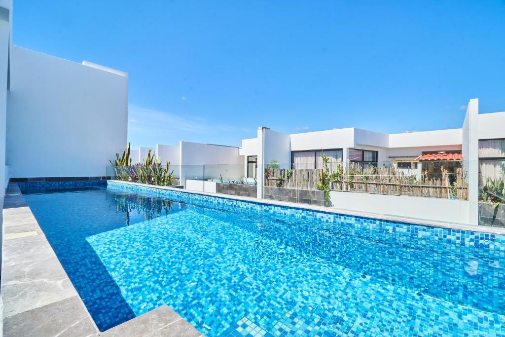 a swimming pool in front of a house at Incredible Luxury Tulum Penthouse with Large Private Pool in Aldea Zama in Tulum
