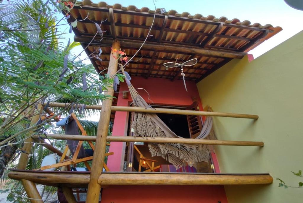 un balcón de una casa con palos de madera en Pacha - Bangalôs em Pipa, en Pipa