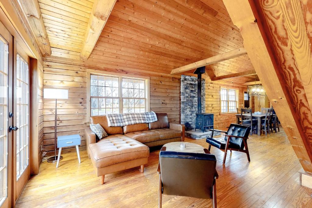 sala de estar con sofá y mesa en Modern Log Cabin with Vineyard Views, en Penn Yan