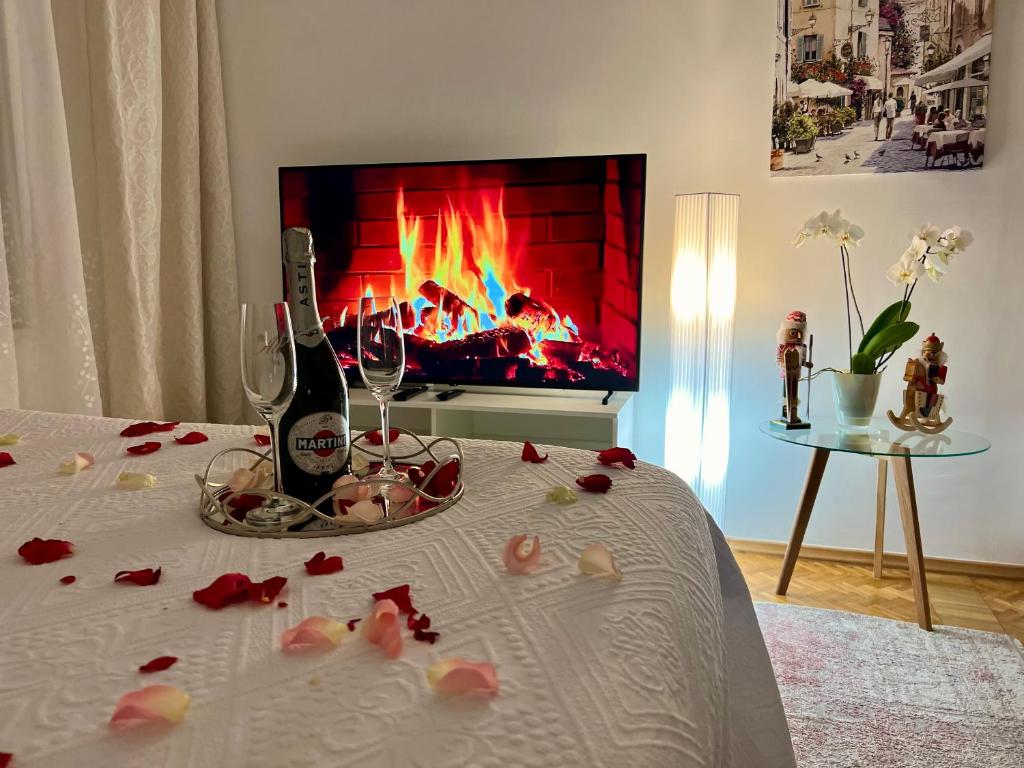 Habitación con mesa con copas de vino y chimenea en Louis & Elza Old Town Romantic apartments, en Wroclaw