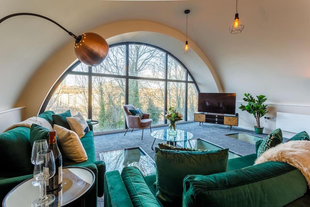 Stylish Duplex 5 min from centre في نيوكاسل أبون تاين: غرفة معيشة بأثاث أخضر ونافذة كبيرة