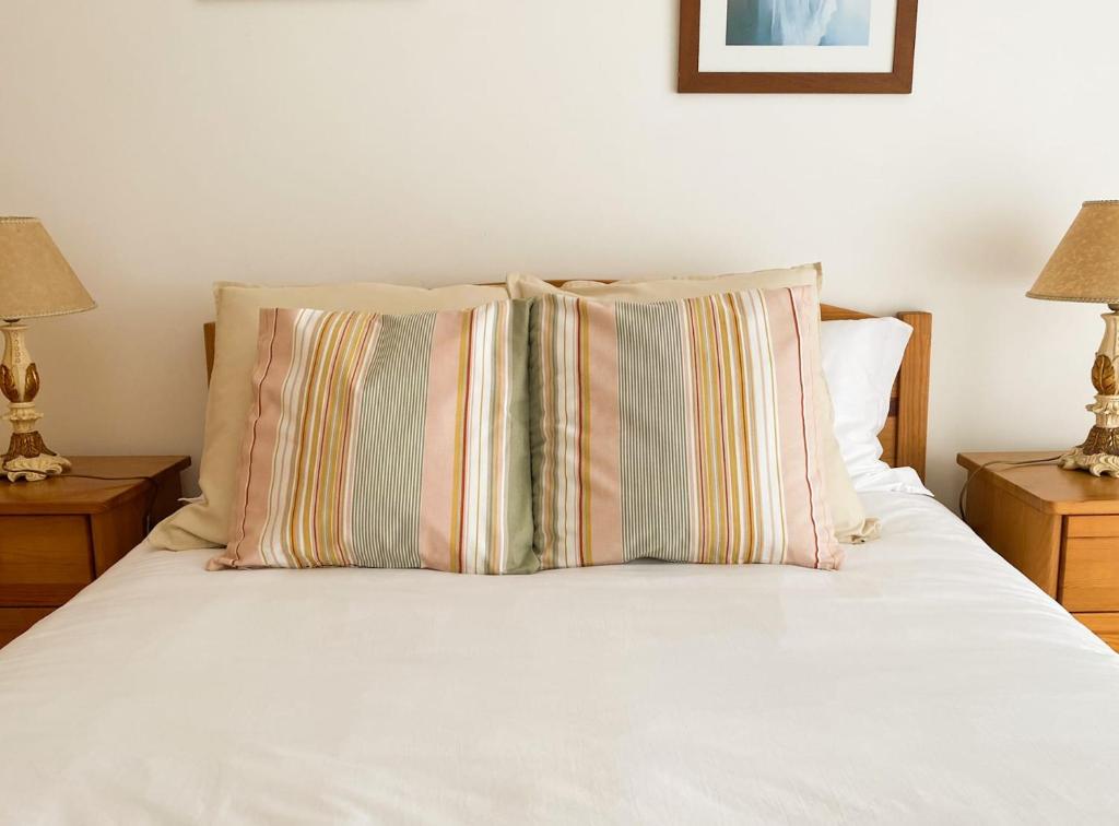a white bed with two pillows and two lamps at T1 Perto da Praia Nazaré -The PI House in Nazaré
