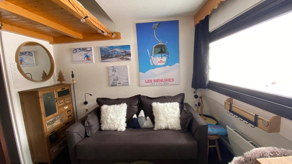 a living room with a couch and a window at Les Menuires centre! Chaleureux studio sur les pistes! in Les Menuires