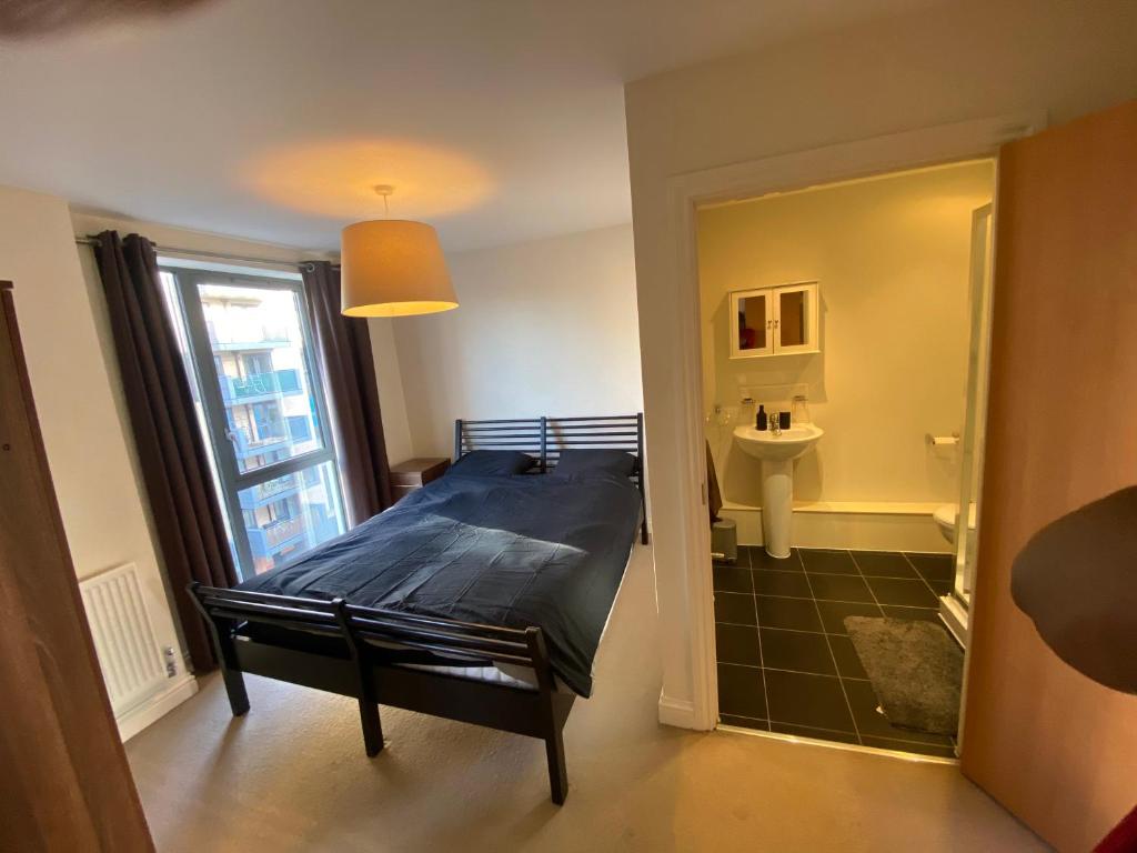 a bedroom with a bed and a sink in a room at Rooms in exquisite and centrally located apartment in Colindale