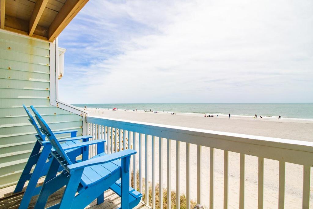 a blue chair sitting on a balcony overlooking the beach at Ocean Dunes 0903 in Kure Beach