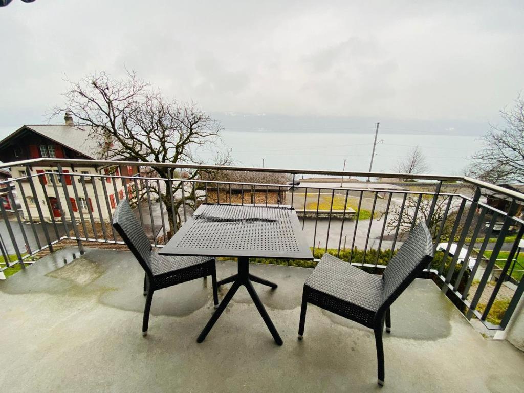 a table and two chairs on a balcony at Lake View Apartment -14 in Niederried