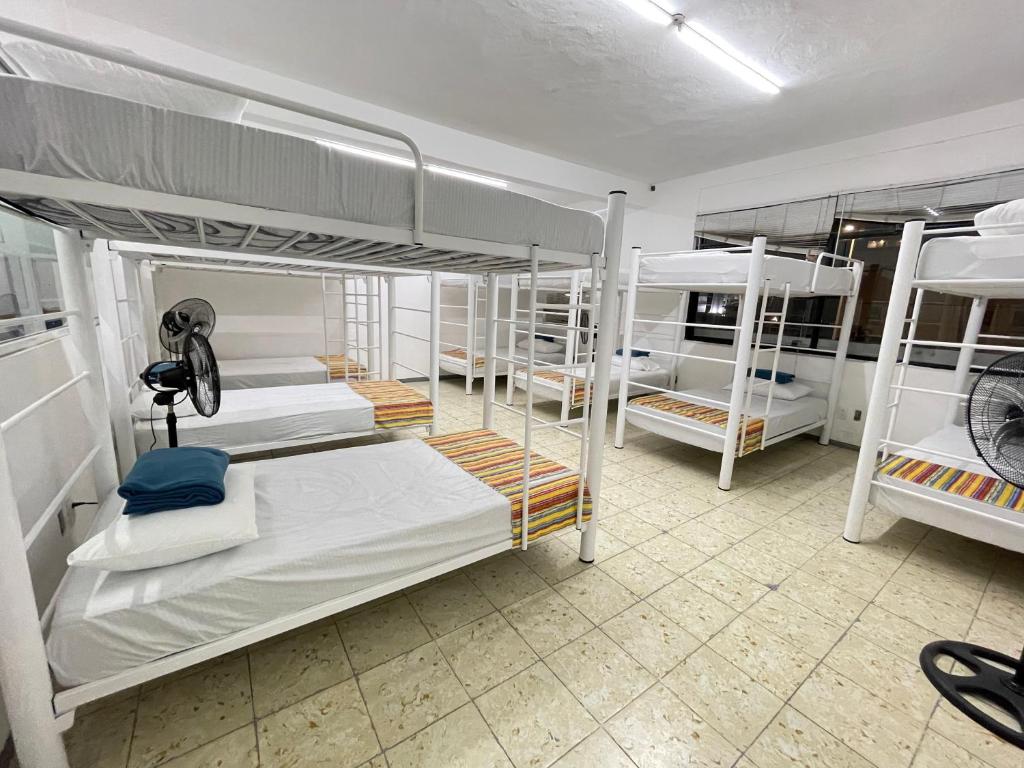 Vive Alegria Hostel في بويرتو فايارتا: غرفة مع العديد من الأسرّة ذات الطابقين في غرفة