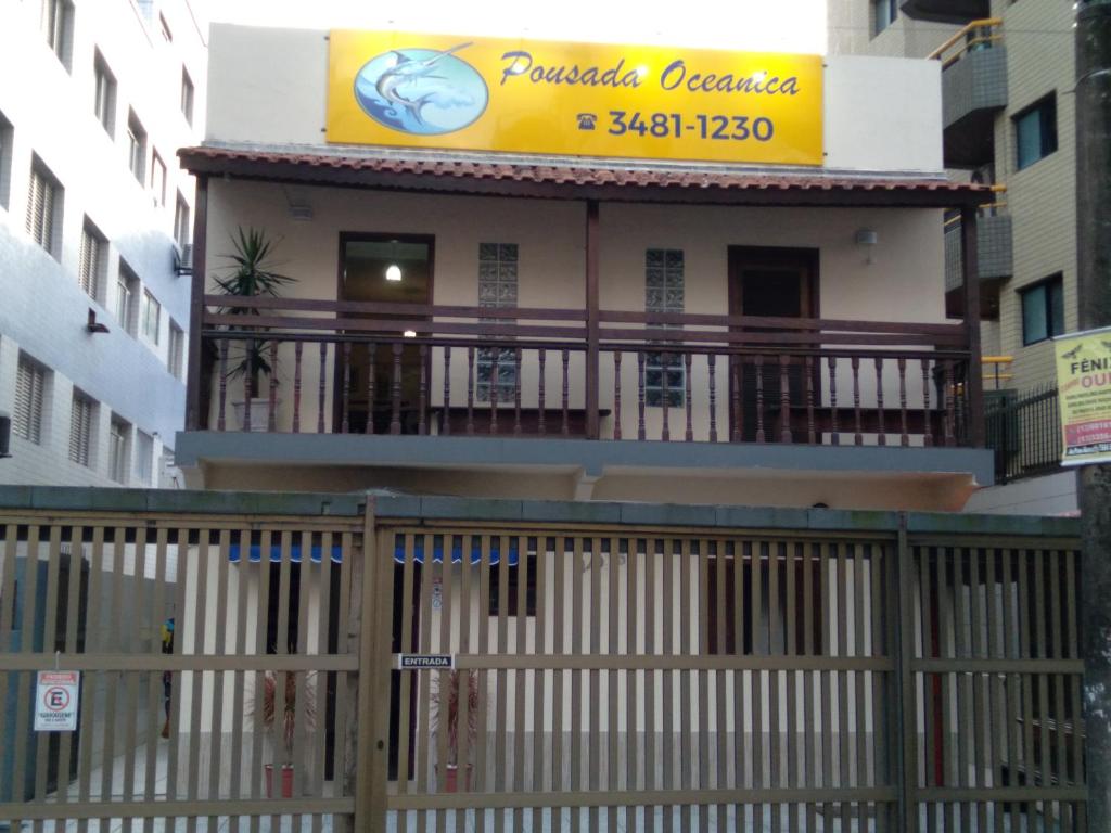 a building with a balcony with a sign on it at Pousada Oceanica in Praia Grande