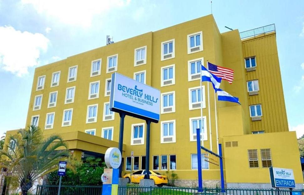 a large yellow building with flags in front of it at Beverly Hills: Hotel and Business in San Salvador