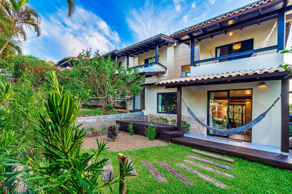 an exterior view of a house with a yard at Pousada Flor de Lotus in Praia do Rosa