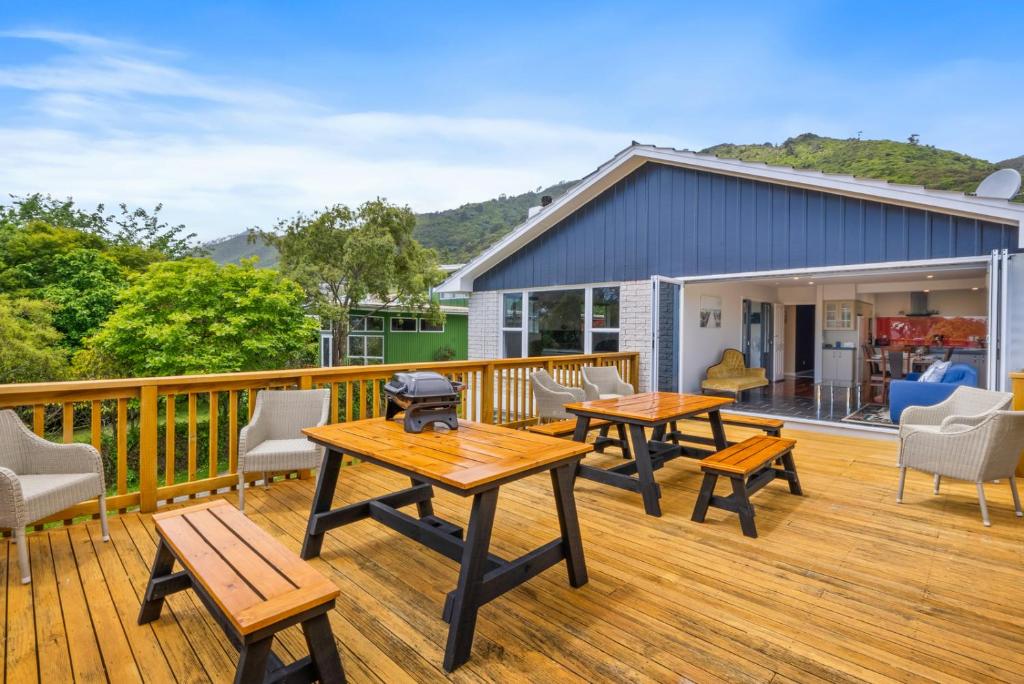 懷卡奈的住宿－Winara Winner - Waikanae Holiday Home，一个带野餐桌和椅子的甲板和一座房子