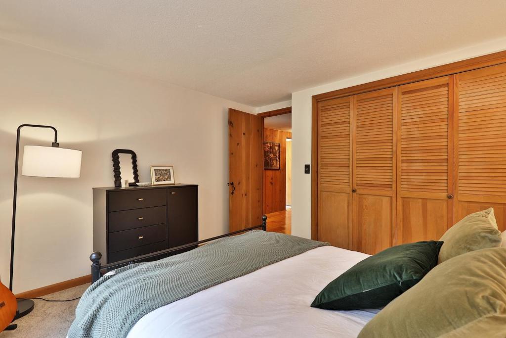 a bedroom with a bed and a wooden closet at Forest Mountain Escape- Beautiful Mountaintop Escape in Mendon, VT, 20 min to Killington 14 to Pico, home in Mendon