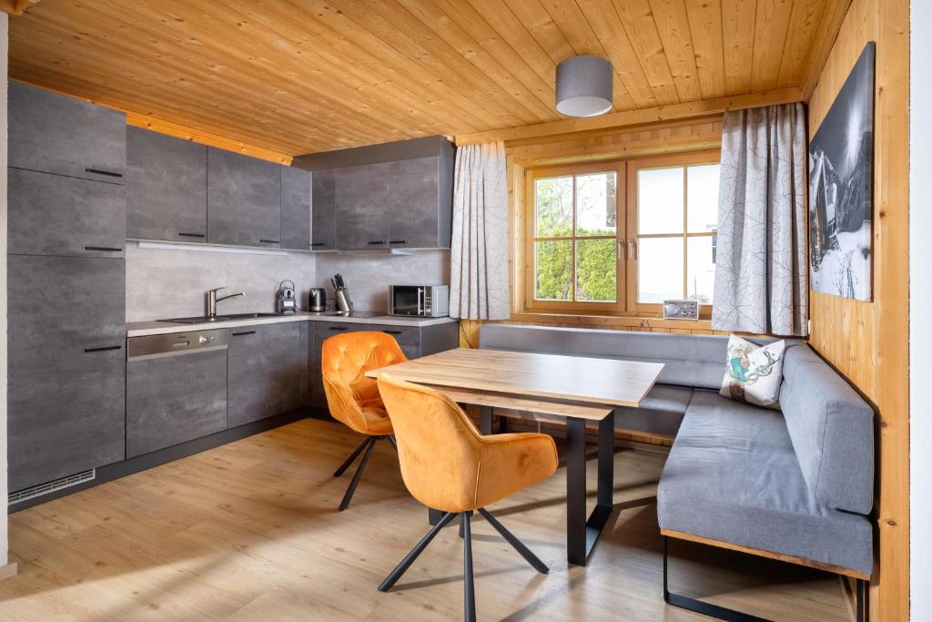 a kitchen with a table and chairs in a room at Apartmenthaus Matri in Wald am Arlberg