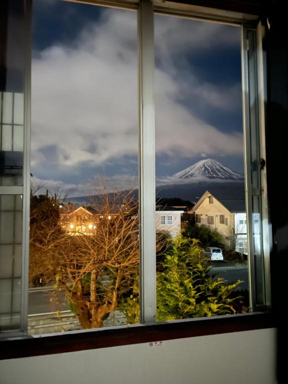 uma janela com vista para uma montanha coberta de neve em 金桂苑 em Fujikawaguchiko