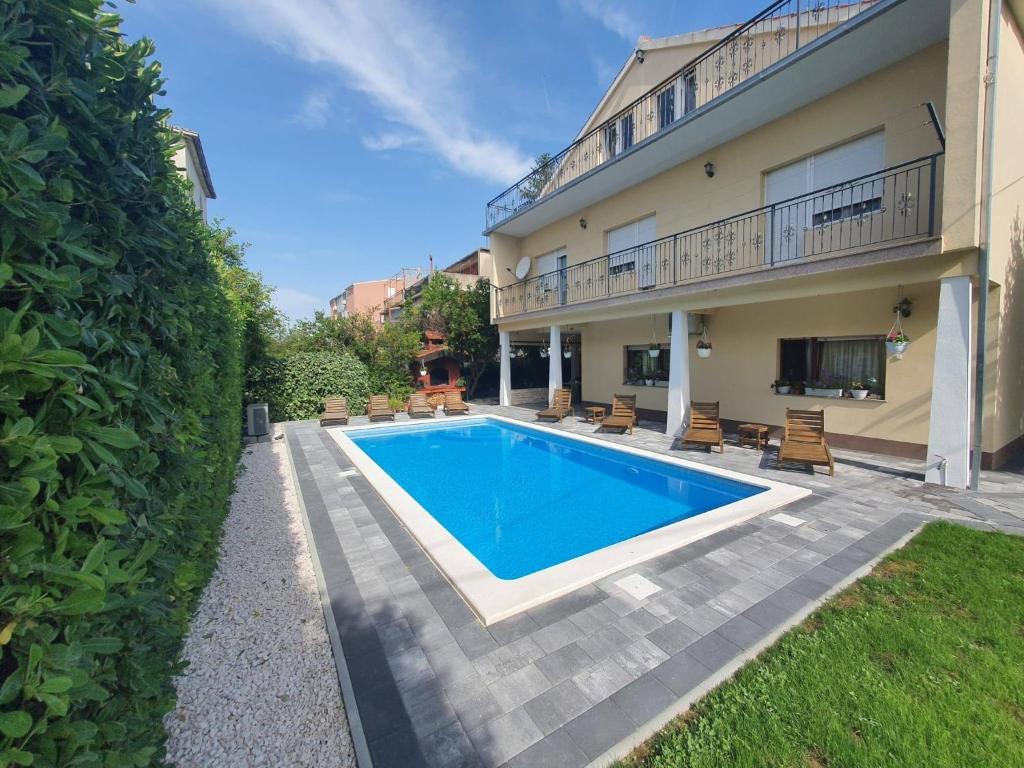 uma piscina em frente a uma casa em Family friendly apartments with a swimming pool Kastel Novi, Kastela - 18645 em Kaštela