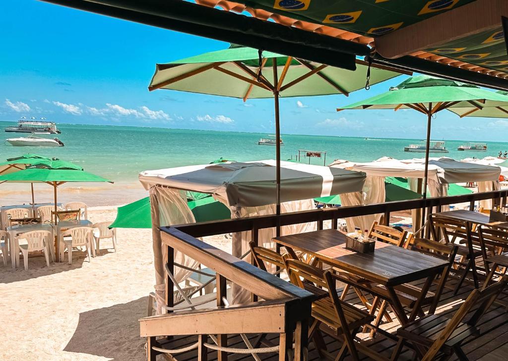 a group of tables and umbrellas on a beach at Beach Point Barra Grande in Maragogi