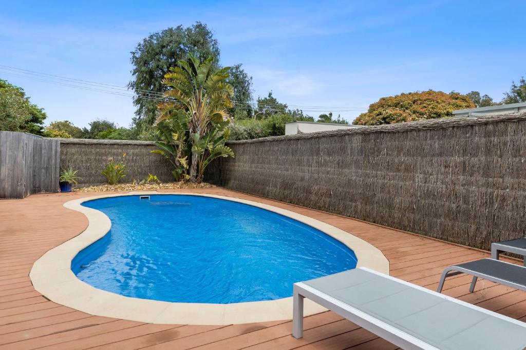 a swimming pool in a backyard with a wooden fence at SANDY ANN at Lonnie in Point Lonsdale