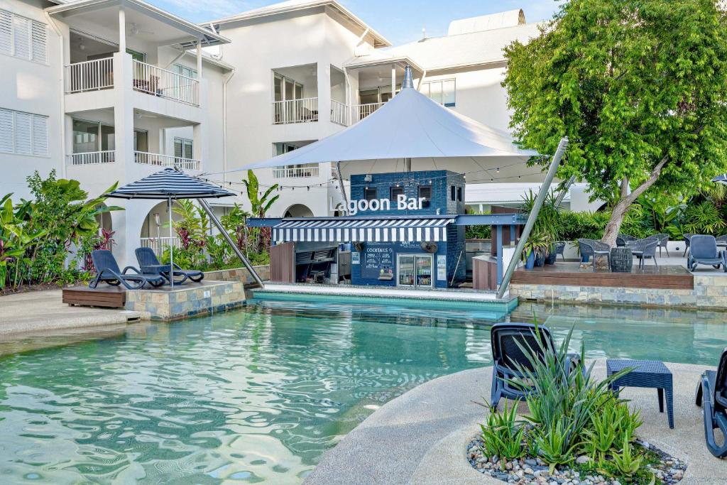a swimming pool in front of a hotel at Mantra PortSea in Port Douglas