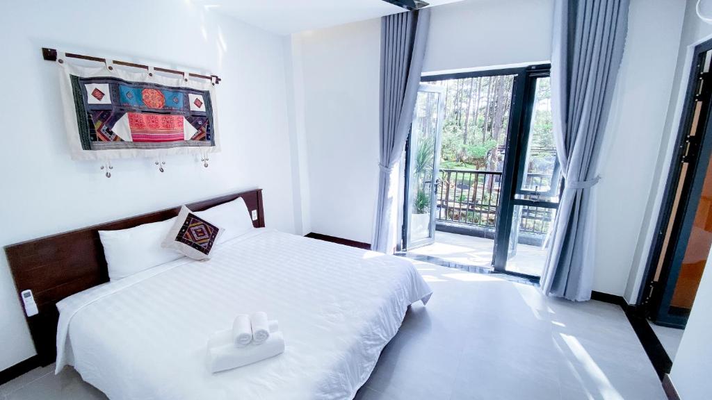 sypialnia z białym łóżkiem i dużym oknem w obiekcie Casa Vanilla Mang Den w mieście Kon Von Kla