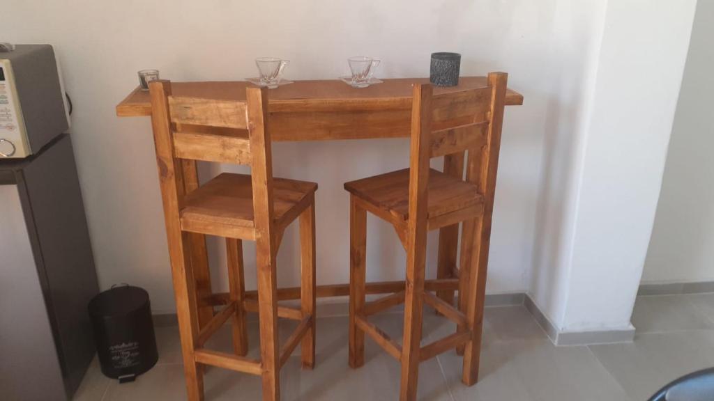 una pequeña mesa de madera con dos copas de vino. en Monoambiente, en Mercedes