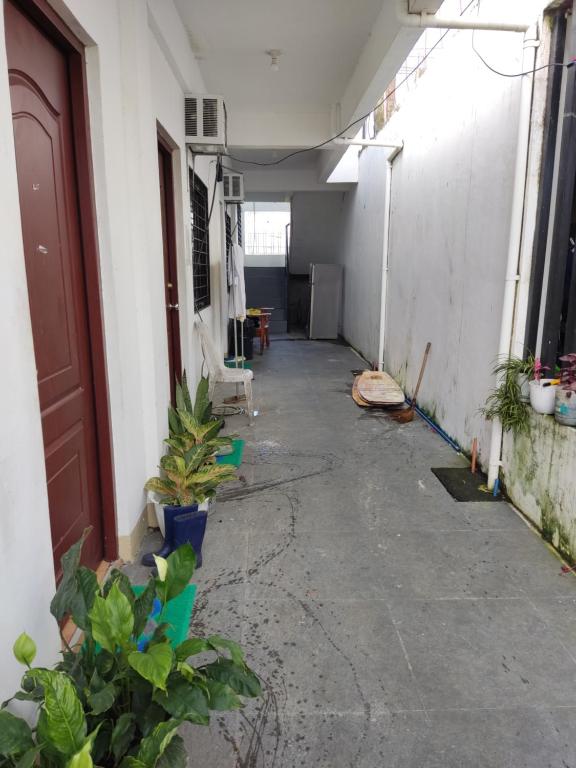 un pasillo vacío de un edificio con plantas y una puerta en Keneth Hostel, 