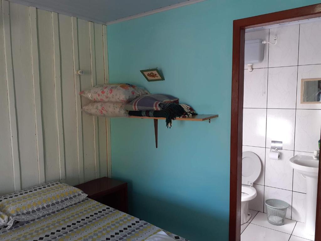 een kleine slaapkamer met een bed en een badkamer bij Pousada Praia Mansa Superagui in Superagui