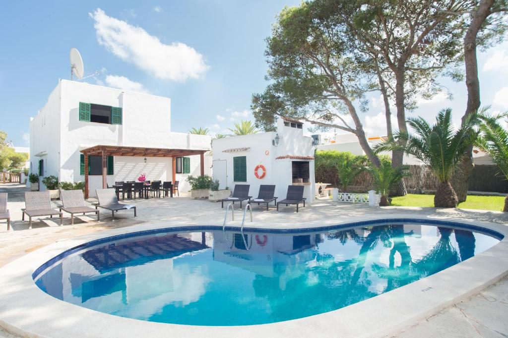 a swimming pool in front of a house at Villa Dos Pinos in Cala d´Or