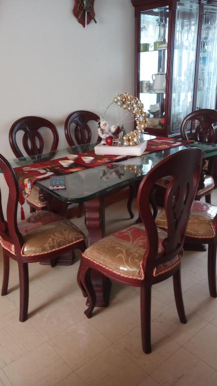 uma sala de jantar com uma mesa de vidro e cadeiras em Como en casa em Bogotá