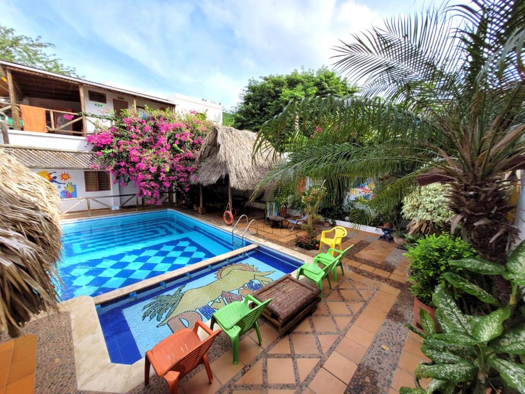 une piscine extérieure avec des chaises et un complexe dans l'établissement Divanga Hostel, à Taganga