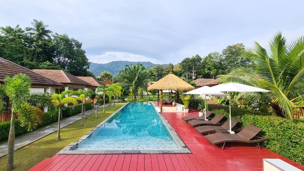 a resort swimming pool with chairs and umbrellas at Verona Lanta Resort in Ko Lanta