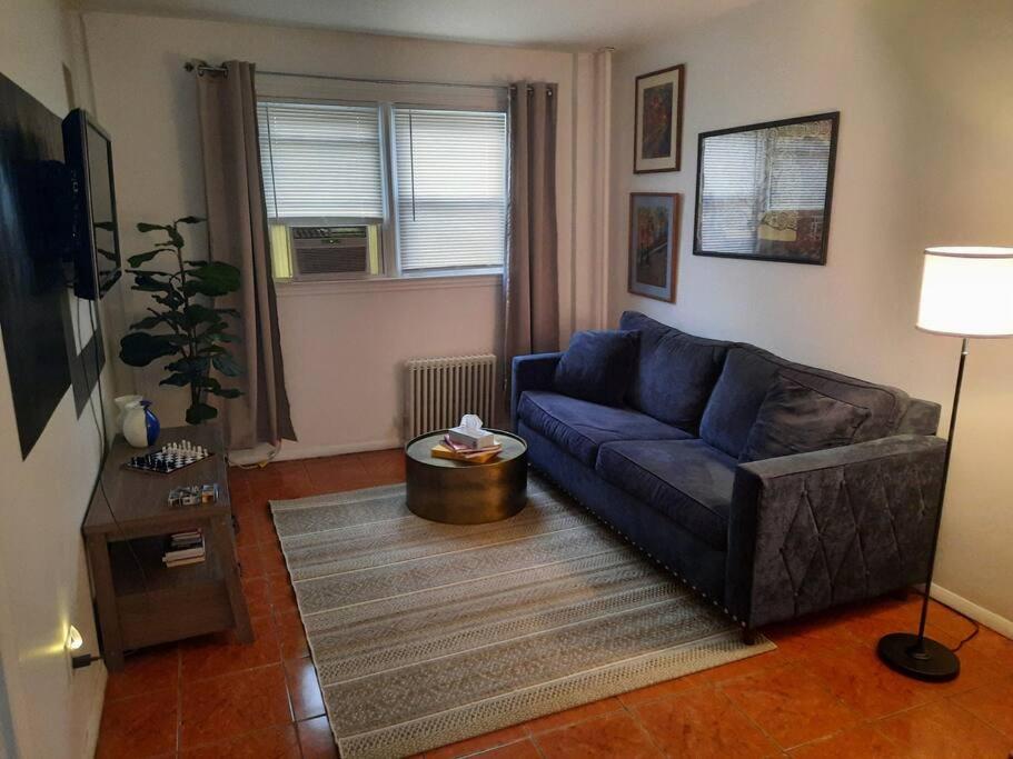 a living room with a blue couch and a table at Pet Friendly Apartment minutes from NYC! in West New York