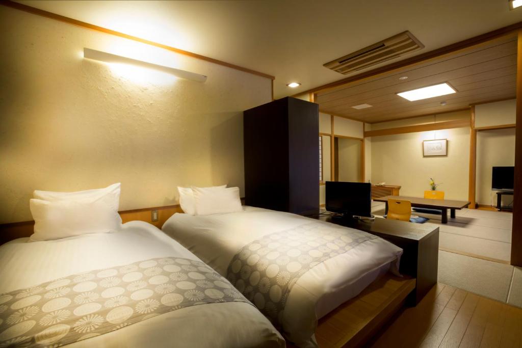 Postel nebo postele na pokoji v ubytování Hotel Kitanoya