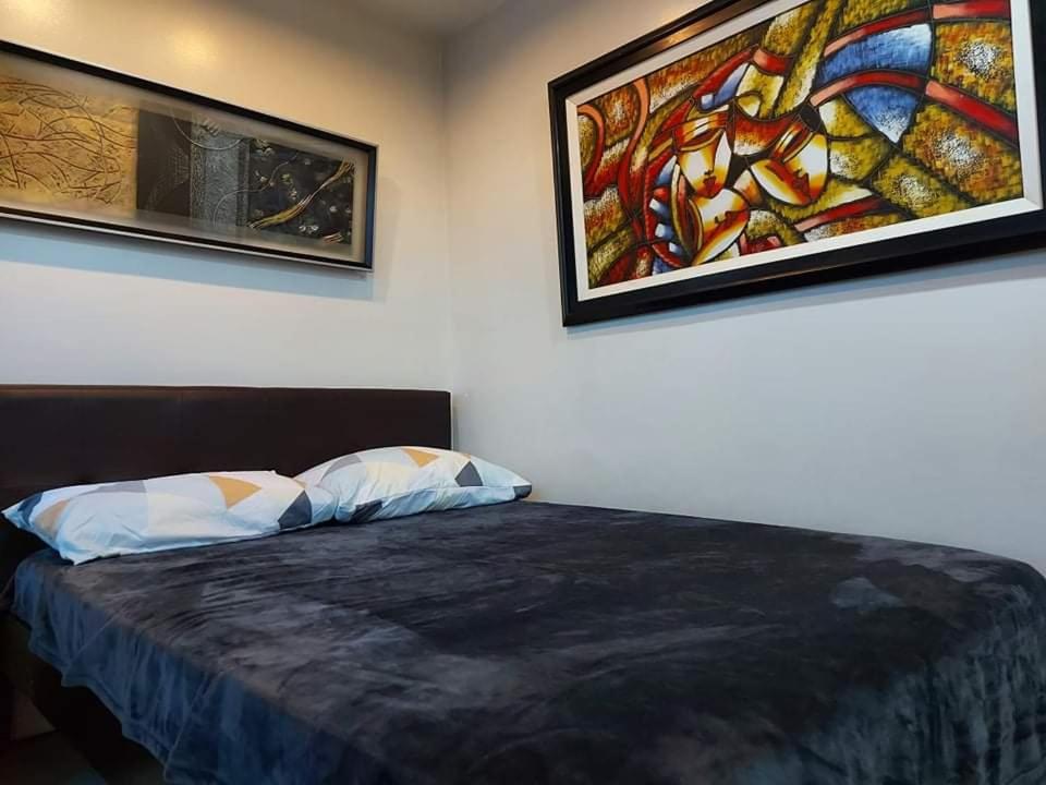 a bedroom with a bed with a painting on the wall at Family Staycation with Pool in Manila