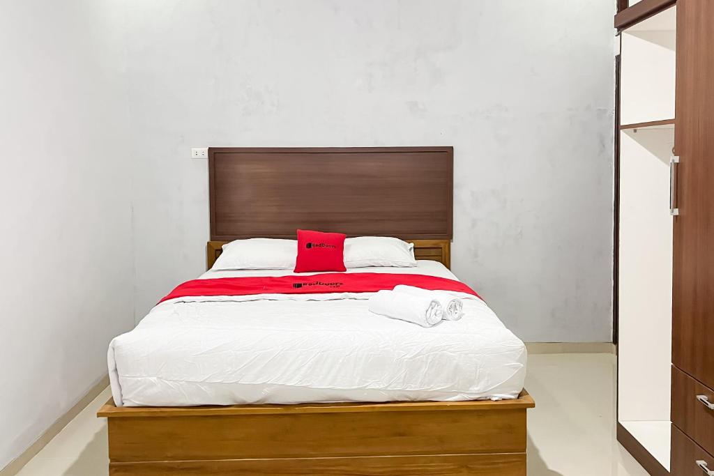 a bedroom with a bed with two towels on it at RedDoorz at Jalan Basuki Rahmat Lampung in Lampung