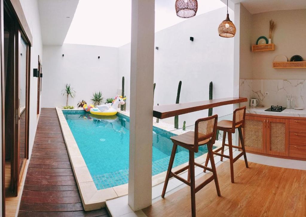 una piscina en una cocina con mesa y sillas en San Villa Syariah, en Banjarbaru