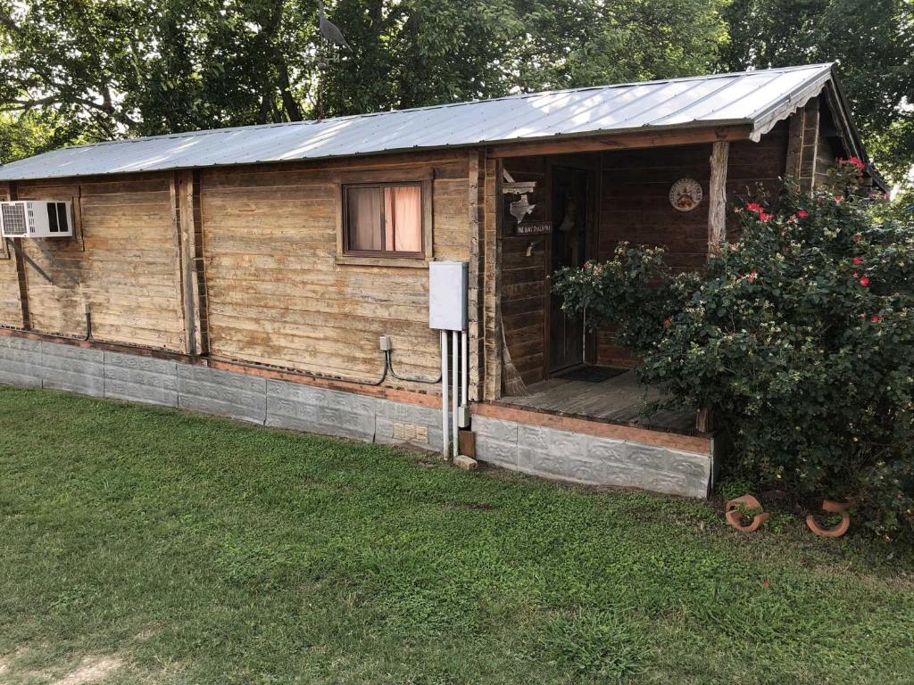 a wooden cabin with a porch in a yard at Country Accents - Lee Cabin in Pipe Creek
