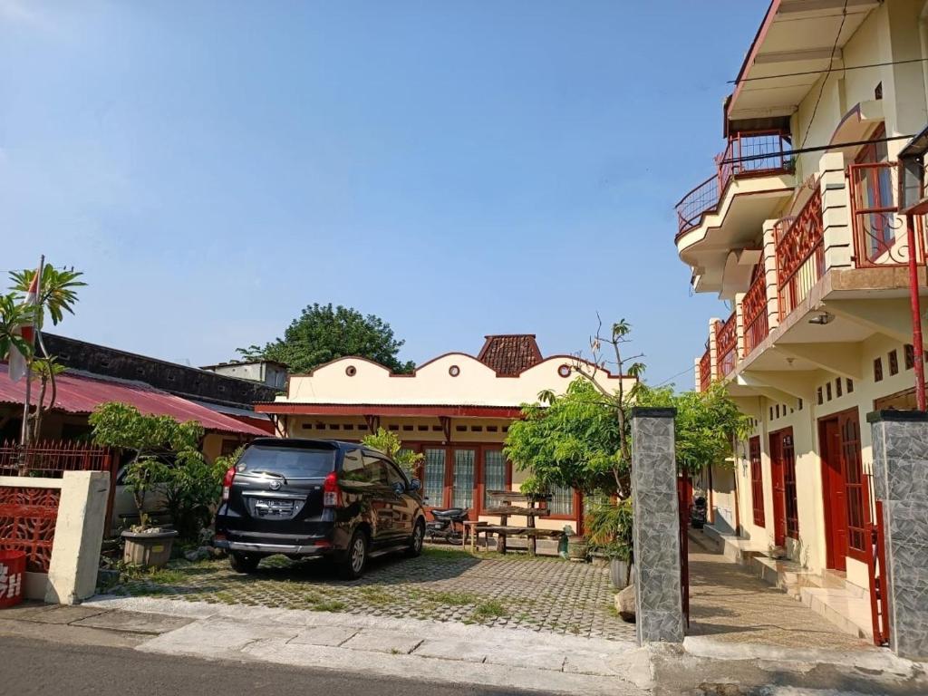 a car parked in a parking lot next to a building at BSH (Bu Sud's House) Yogyakarta in Yogyakarta