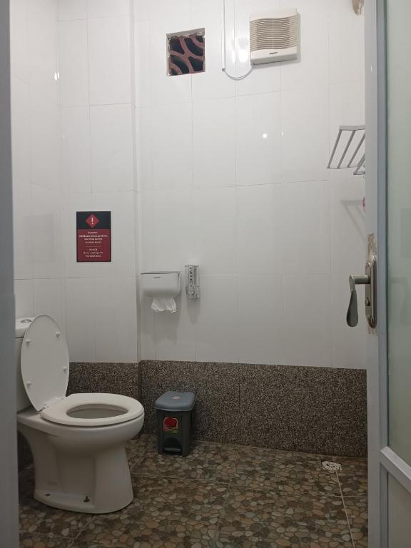 a bathroom with a toilet and a trash can at BSH (Bu Sud's House) Yogyakarta in Yogyakarta