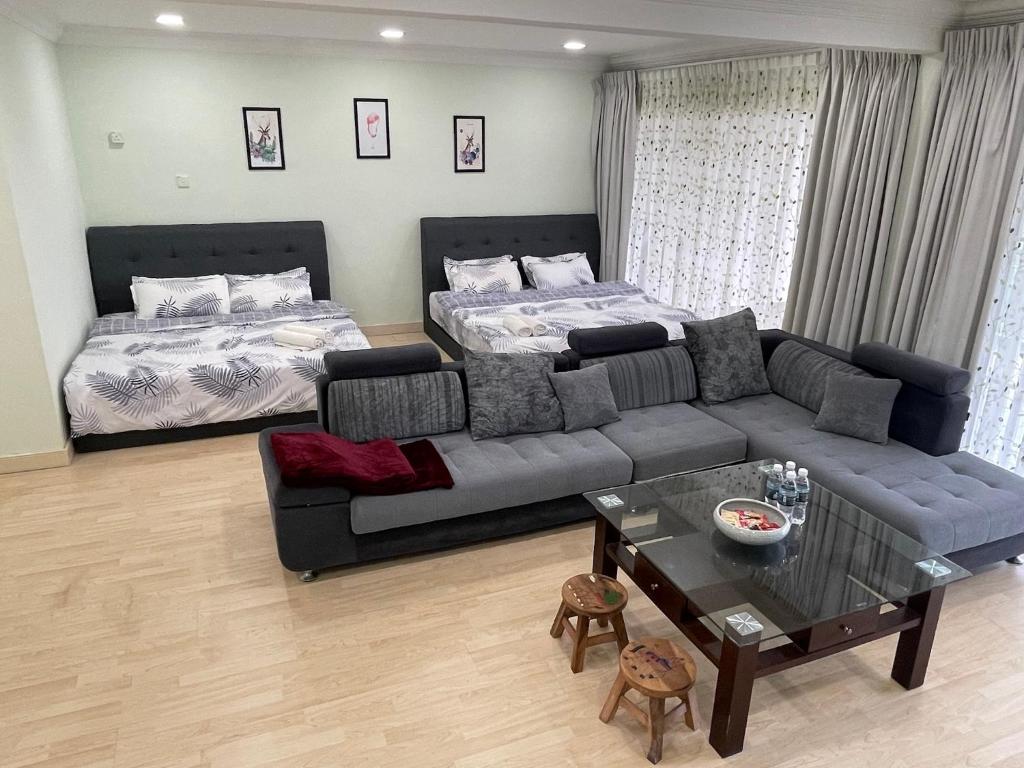 a living room with a couch and a bed at EquatorialHillResort SunsetView 10Min Popular FARM in Brinchang