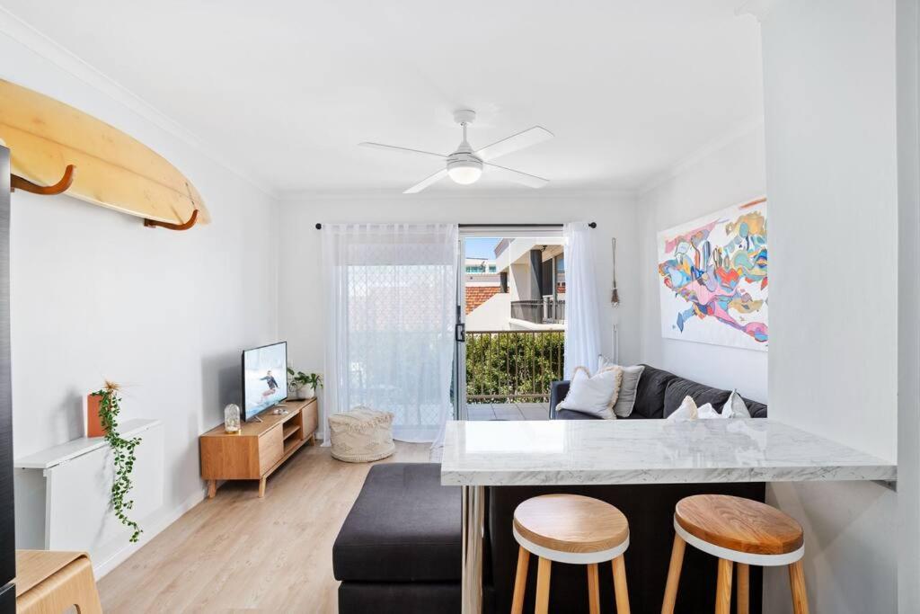 una cucina e un soggiorno con bancone e sgabelli di Alfred Street - Hosted by Burleigh Letting a Gold Coast