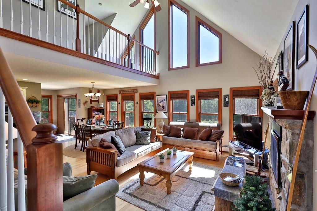 a living room with couches and a table at Cortina Mountain Chalet - Outdoor Hot Tub - Close to Pico and Killington Mountains home in Mendon