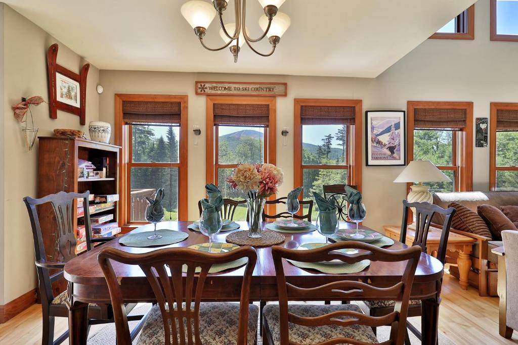 Un comedor con mesa y sillas en Cortina Mountain Chalet - Outdoor Hot Tub - Close to Pico and Killington Mountains home, en Mendon
