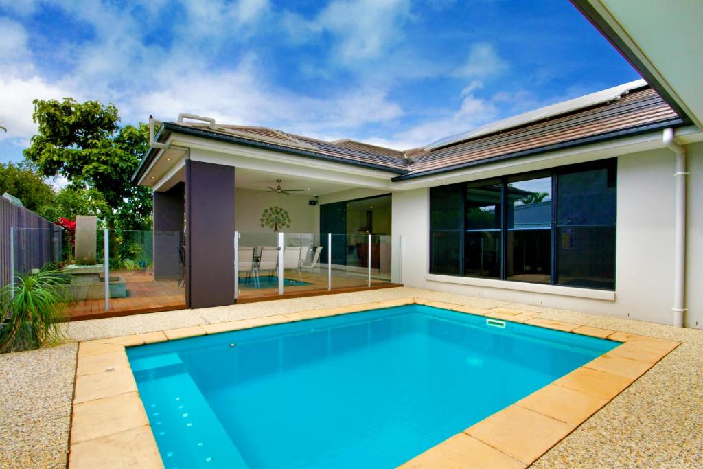 a swimming pool in front of a house at Grand Parade in Buddina