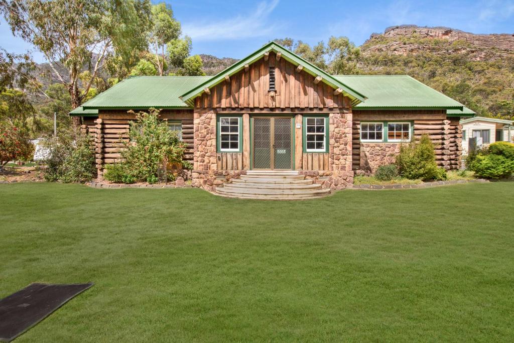 a log home with a lawn in front of it at Breeze Holiday Parks - Halls Gap in Halls Gap