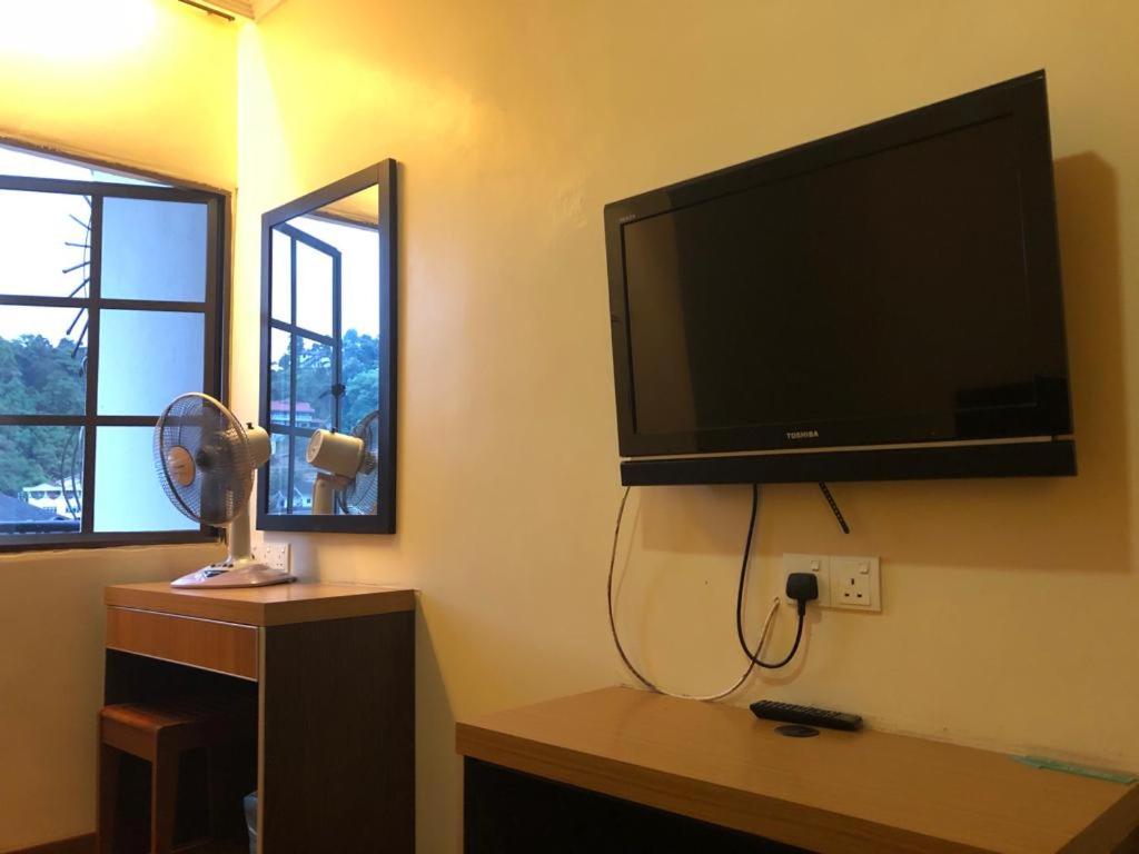 a living room with a flat screen tv on the wall at Hotel Chua Gin in Cameron Highlands