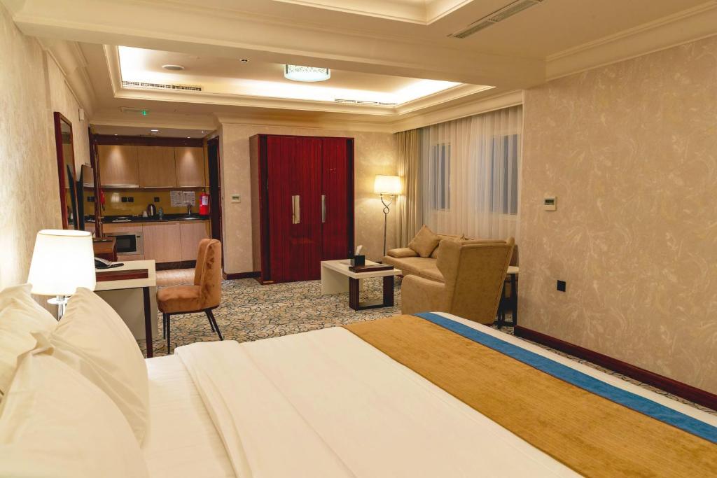 a hotel room with a bed and a living room at Ivory Inn Hotel Doha Qatar in Doha